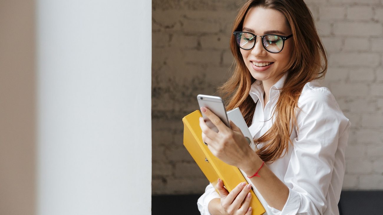 happy-business-woman-indoors-using-mobile-phone-P9WS3SD