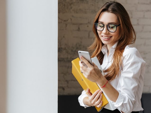 happy-business-woman-indoors-using-mobile-phone-P9WS3SD