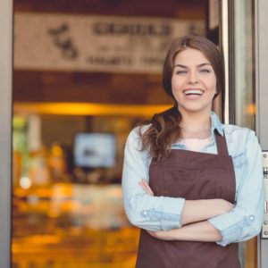 Smiling woman in an apron in the bakery