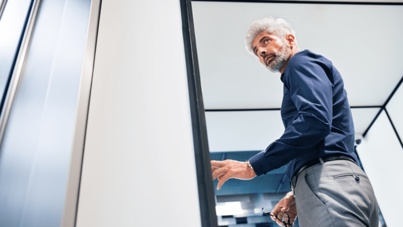 mature-businessman-in-the-office-standing-P4MENHG