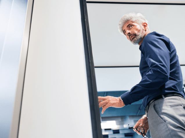 mature-businessman-in-the-office-standing-P4MENHG