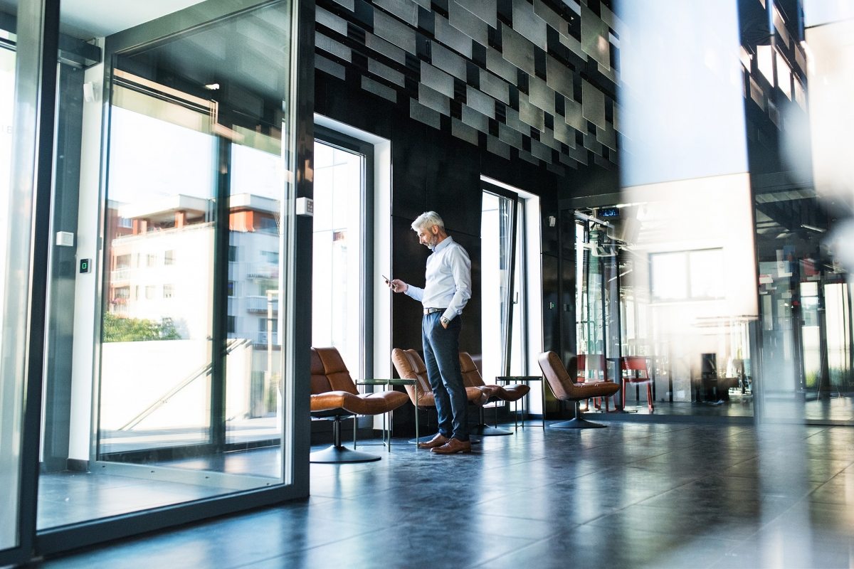 Mature-businessman-with-smartphone-in-the-office.