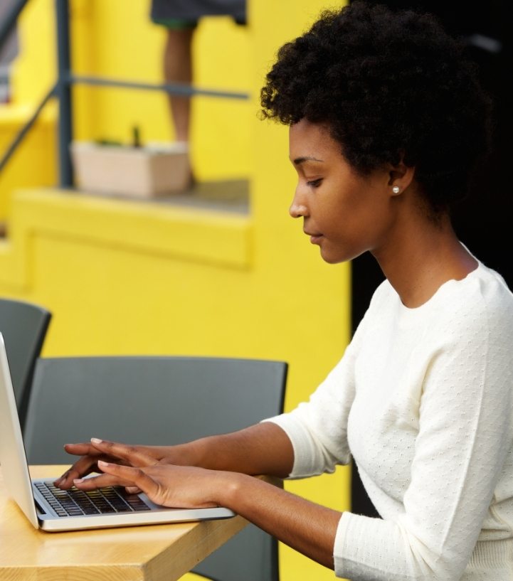 attractive-young-woman-using-laptop-outside-P9RLFGU