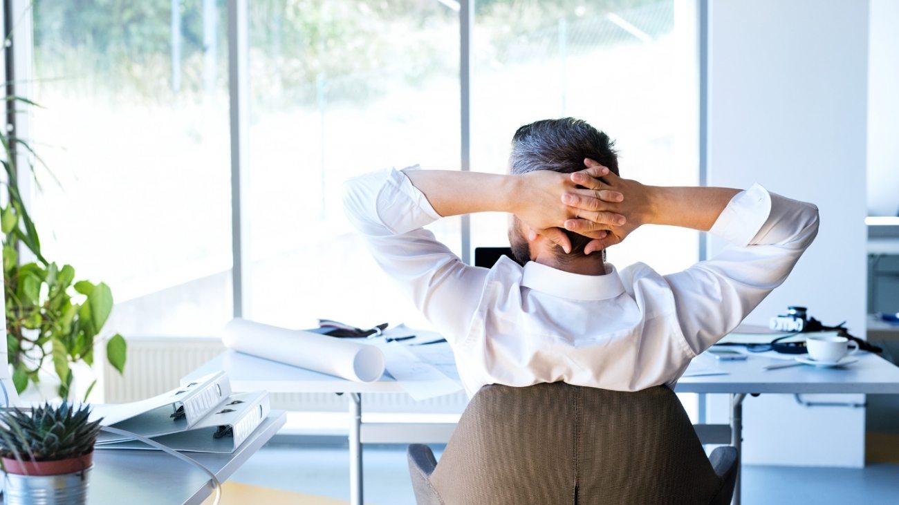 Businessman at the desk in his office resting.