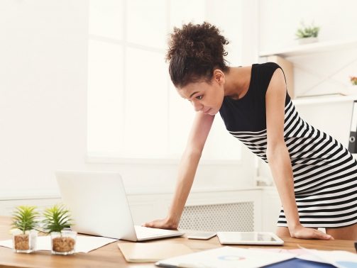 business-woman-working-on-laptop-at-office-PRFJKQJ