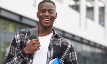 portrait-of-male-student-standing-outside-college-P9XQ4UM