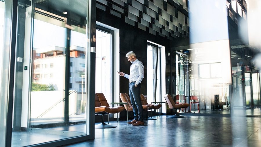 Mature-businessman-with-smartphone-in-the-office.
