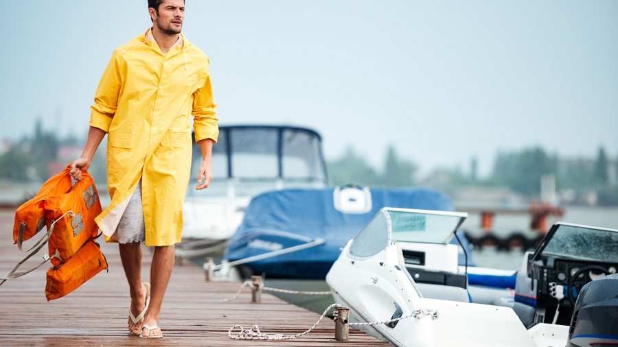 sailor-in-yellow-cloak-at-the-pier-holding-life-PX7M94D