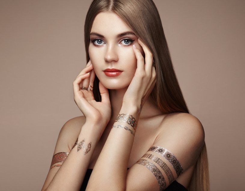 Fashion portrait of elegant woman with magnificent hair. Blonde girl. Perfect make-up. Girl in elegant dress. Flash tattoo gold