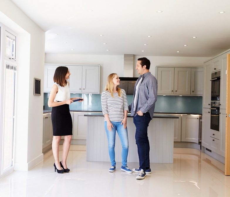 realtor-showing-young-couple-around-property-for-PDHK2DX