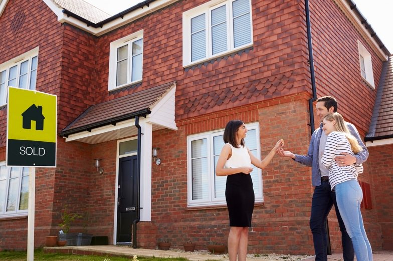 young-couple-collecting-keys-to-new-home-from-PJC4FXU