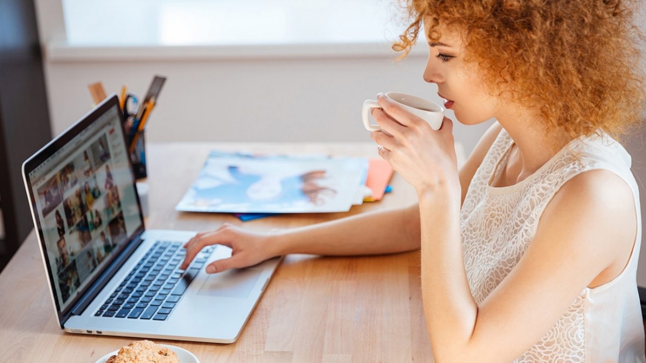 woman-photographer-drinking-coffee-and-working-PJNBP6U